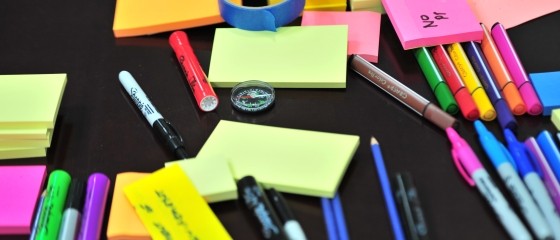 desk top with variety of office supplies like pencils, post-it notes, pens.