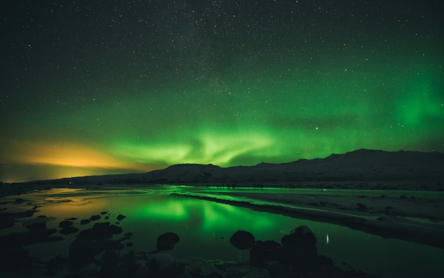 Green-hued Northern Lights over a mountain range